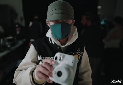 a man wearing a face mask holding a camera