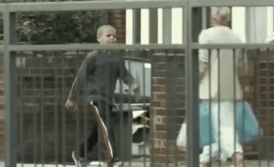 a man is walking behind a fence with a skateboard