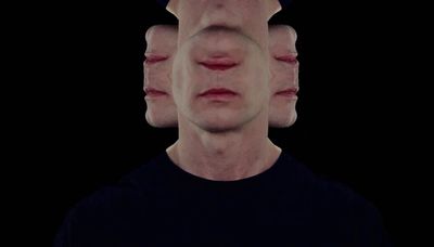 a man's face is reflected in the image of another man's face