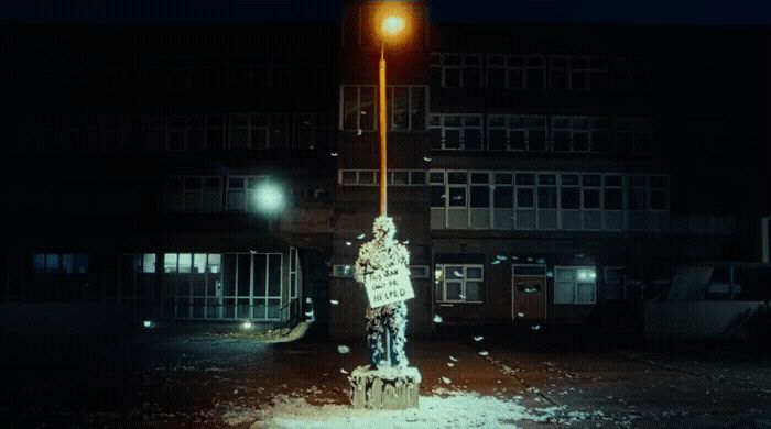 a person holding a sign in front of a building