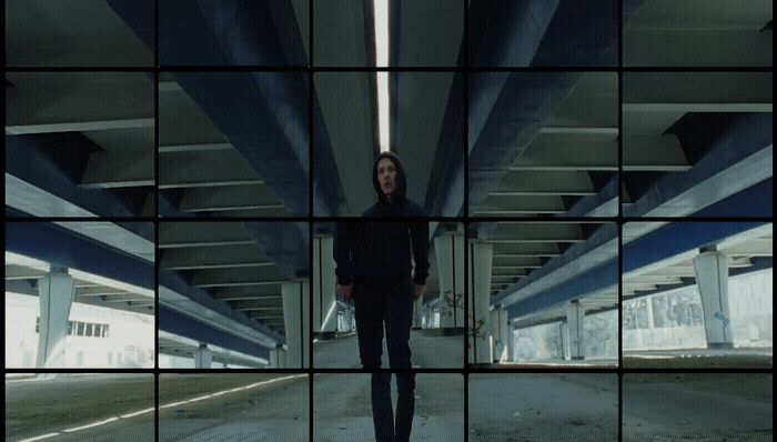 a man standing in a parking garage next to a bridge