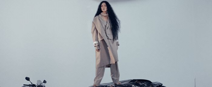 a woman standing on top of a motorcycle