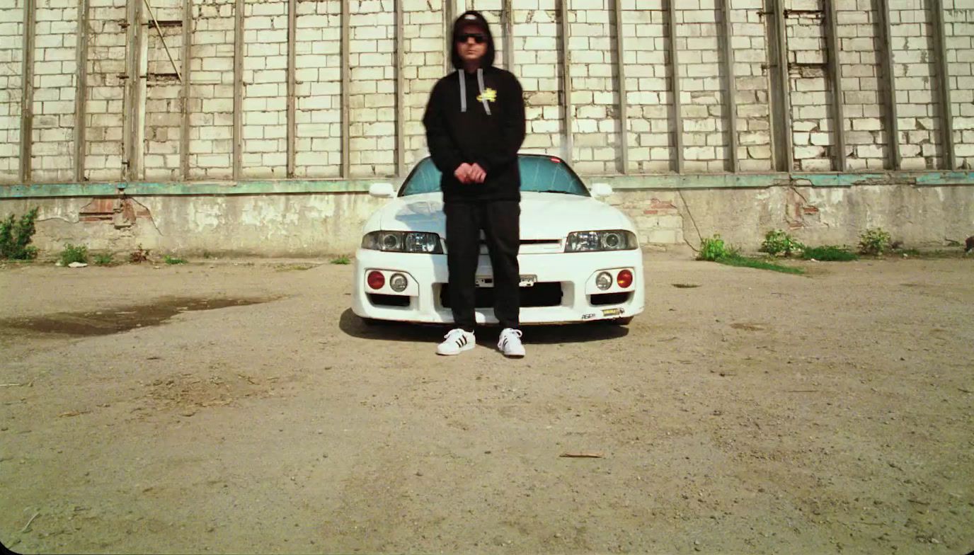 a man standing in front of a white car