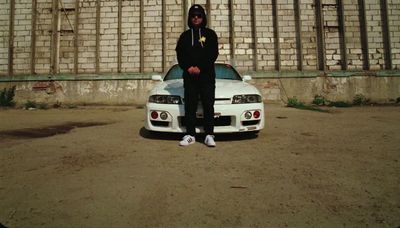 a man standing in front of a white car