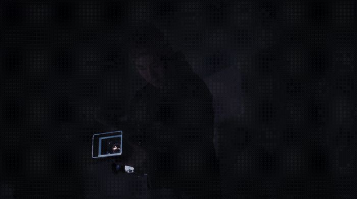 a person standing in the dark holding a camera