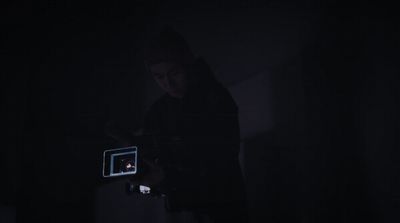 a person standing in the dark holding a camera