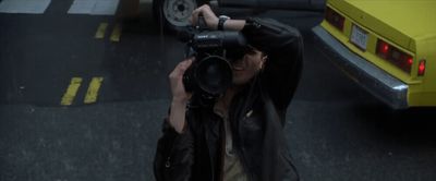 a man taking a picture of a yellow car