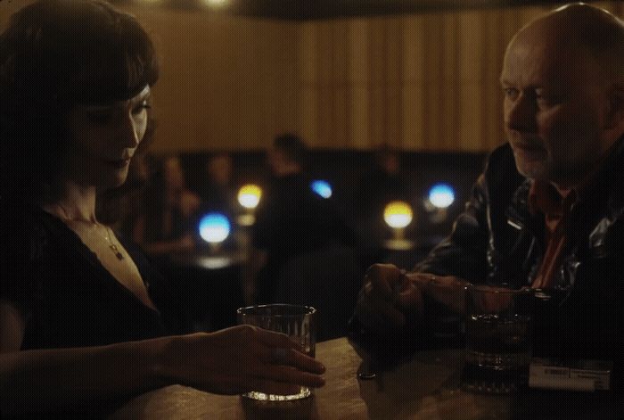 a man and a woman sitting at a bar