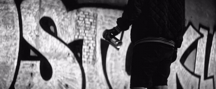 a man riding a skateboard on top of a graffiti covered wall