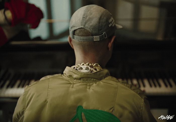 a man in a baseball cap is looking at a piano