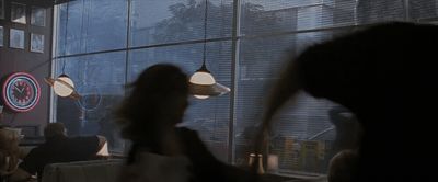 a woman standing in front of a window in a dark room