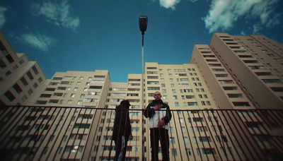 two people standing in front of a tall building