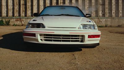 a white sports car parked in a parking lot