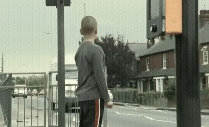 a man standing on the side of a road next to a traffic light