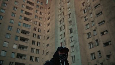 a man standing in front of a tall building