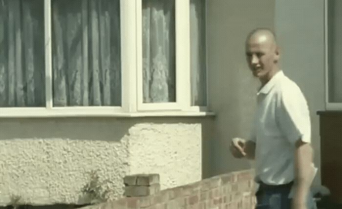 a man standing in front of a brick house