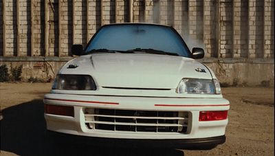 a white car parked in front of a fence