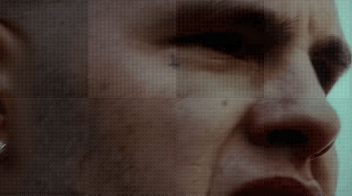 a close up of a man's face with ear piercings