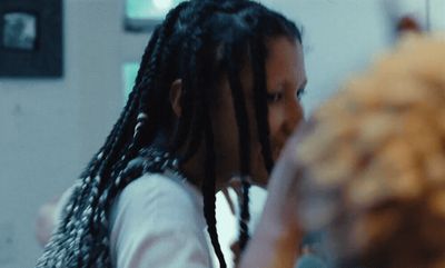 a woman with dreadlocks standing in front of a mirror