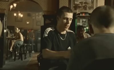 a man sitting at a bar talking to another man