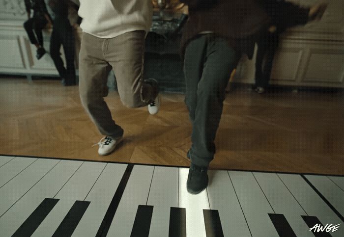 a couple of people that are standing on a piano