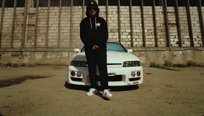 a man sitting on the hood of a white car