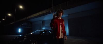 a man standing next to a car in the dark