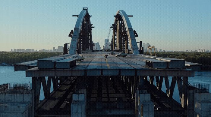 a bridge that is over water with a city in the background