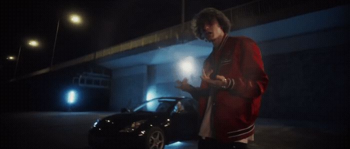 a man standing next to a car in the dark