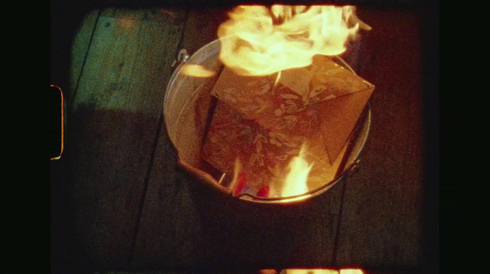 a fire burning in a pot on a wooden table