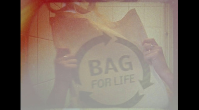 a person holding up a bag for life sign