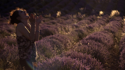 a woman standing in a field of lavender flowers