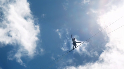 a person on a tightrope high up in the sky