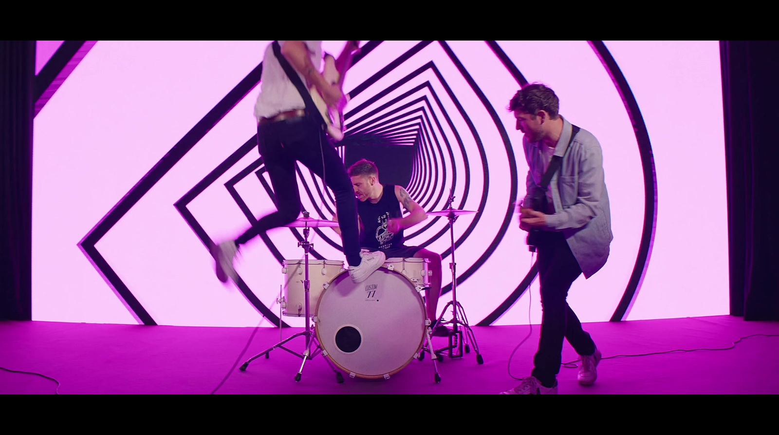 a group of young men standing around a drum set