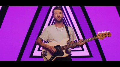 a man holding a bass guitar in front of a purple background