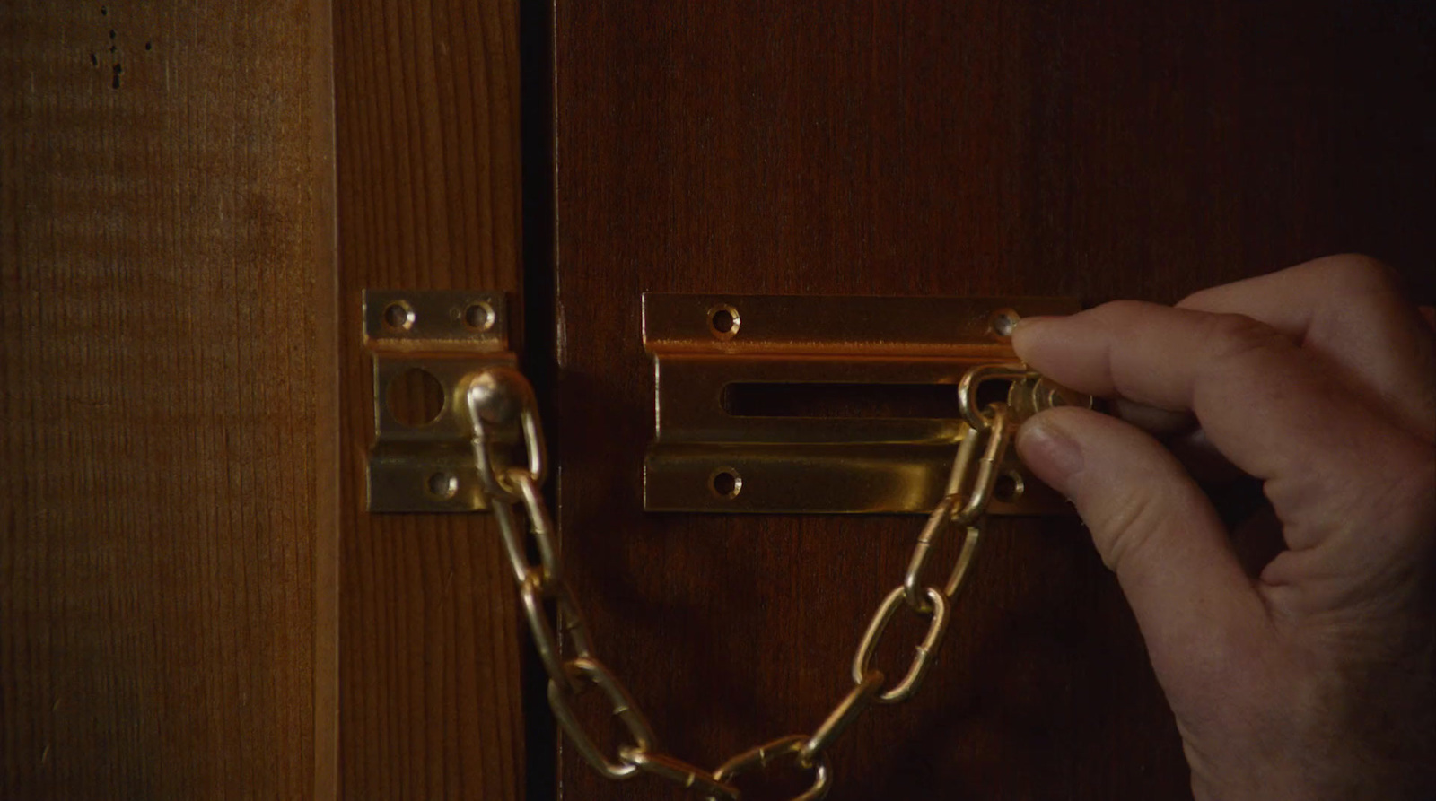 a person is holding a chain to a door