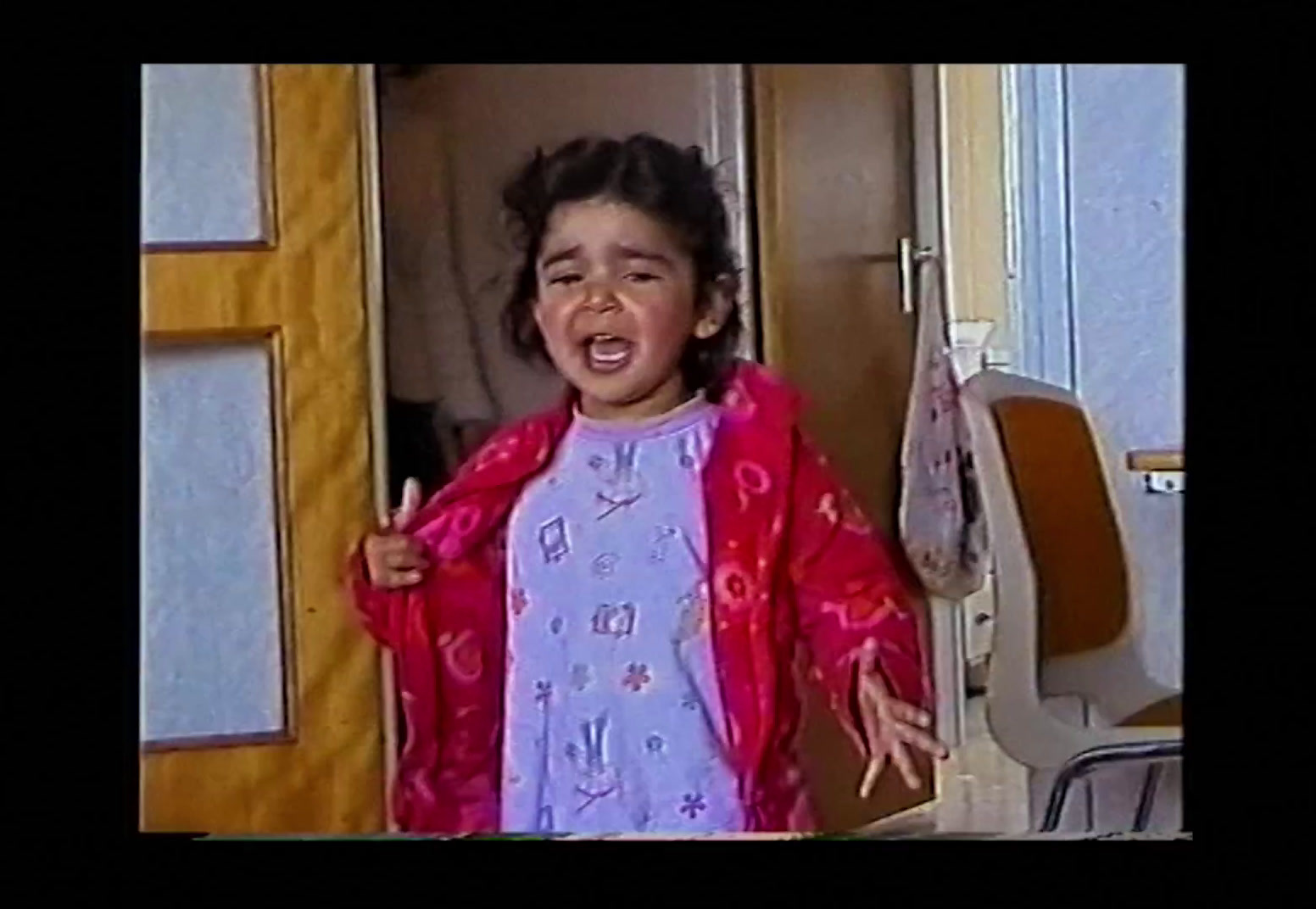 a little girl standing in front of a door