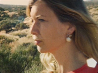 a woman in a red shirt is standing in a field