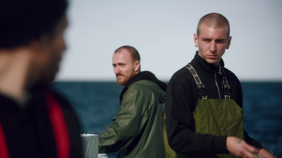 two men standing next to each other near the ocean