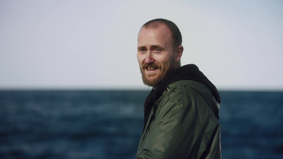 a man standing in front of a body of water