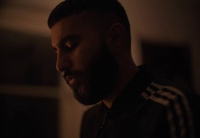 a man in a dark room looking at his cell phone