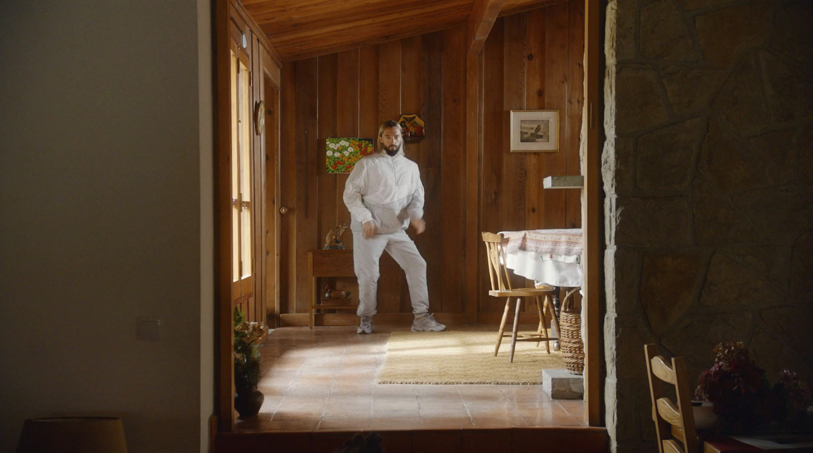 a man in a white suit standing in a room