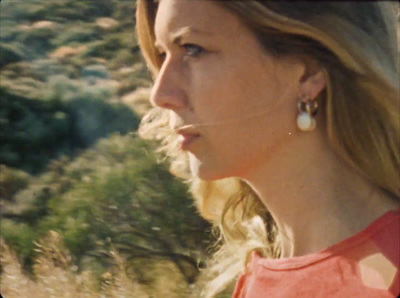 a woman in a red shirt is looking out a window