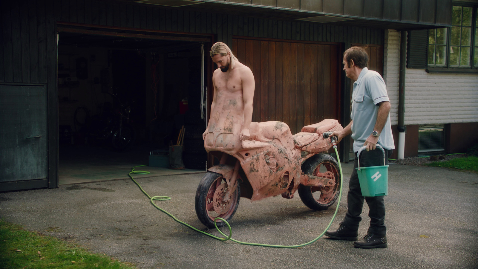 a man standing next to a pink motorcycle