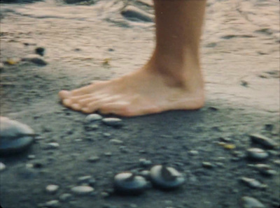 a close up of a person's bare foot on a beach