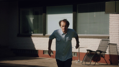 a man in a blue shirt is playing with a frisbee