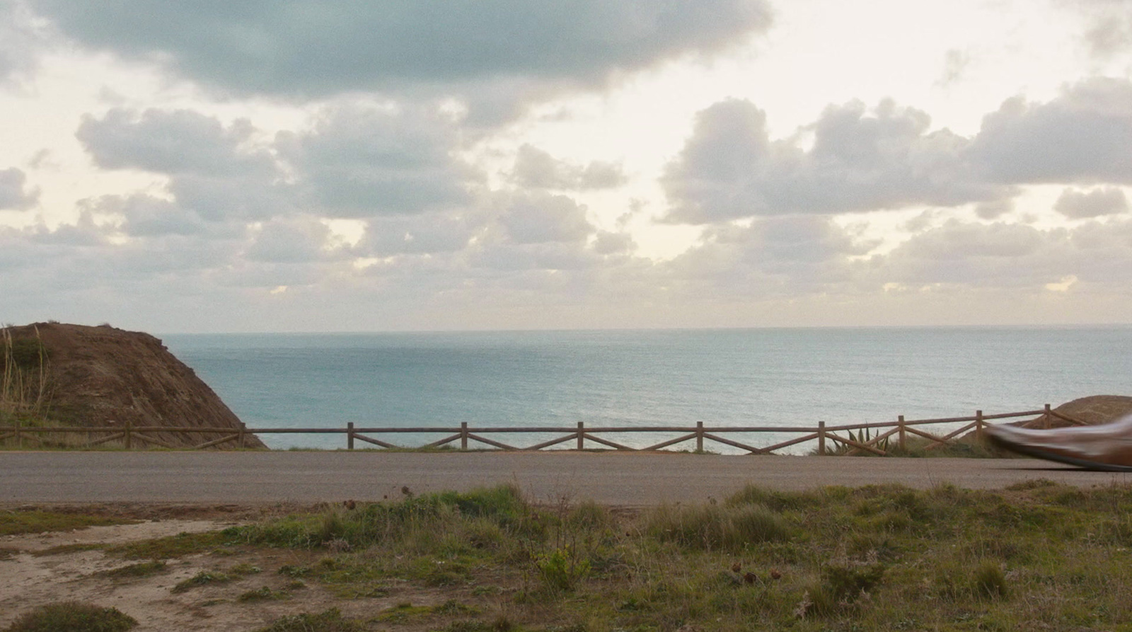 a motorcycle parked on the side of a road near the ocean