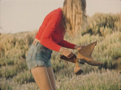 a woman in a red shirt is holding a pair of shoes