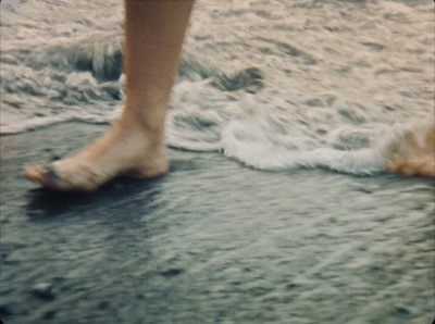 a close up of a person walking on a beach