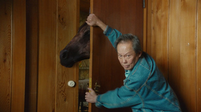 a man in a blue robe petting a horse